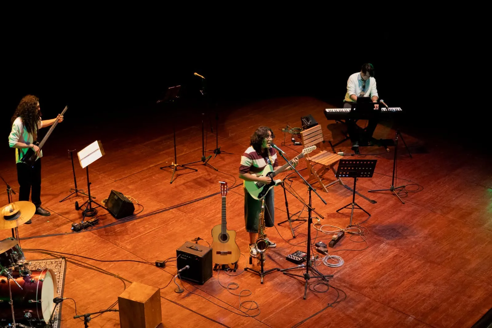 Nelú con su banda en el escenario del Teatro Hidalgo, con guitarra eléctrica, bajo y teclado.